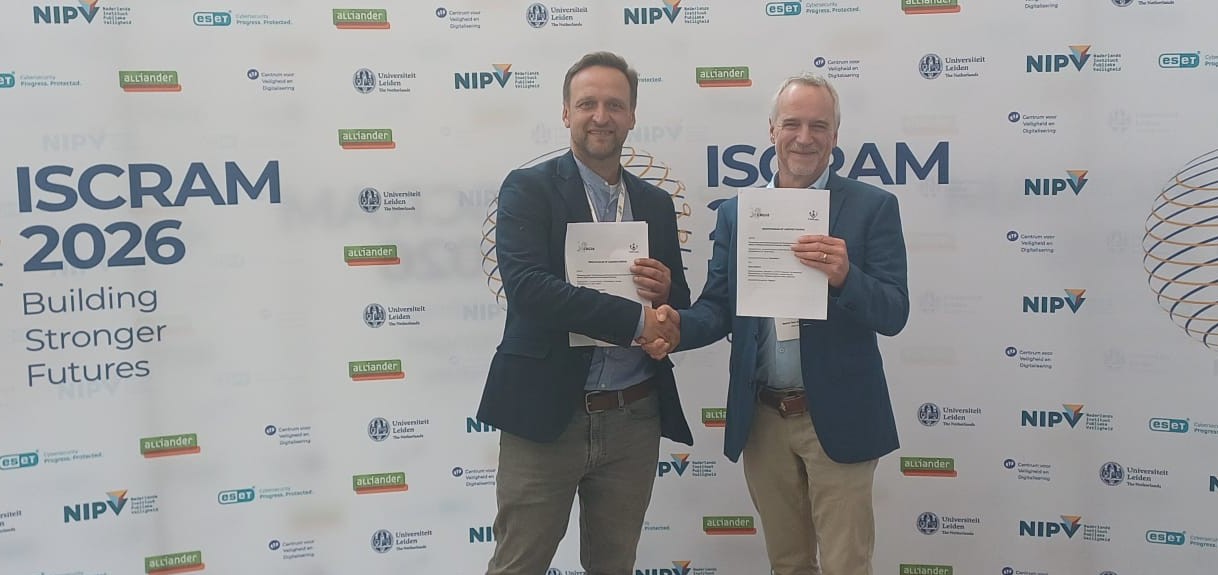 Bartel Van de Walle and Adam Widera with the signed MoU at ISCRAM 2026 in The Hague
